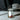 Small dropper bottle of rose petals and oil with a label that says attraction on a marble surface with light refracting