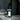 Glass dropper bottle of ritual oil with dried botanicals on a marble surface with a dark background