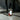 Small glass bottle of rose petals and oil with a label that says attraction on a marble surface with a dark background