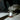 Dropper of oil pouring into a small glass bottle with a label that says attraction