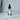 Glass dropper bottle with a label that says opulence and a crystal on a marble surface with a white curtain background